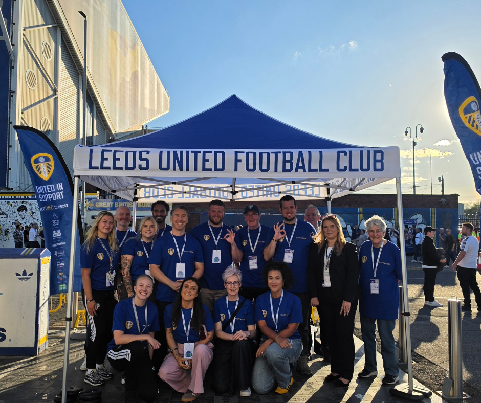 A group of people under a tent with the Leeds United Football club branding and the text: Leeds United Football Club